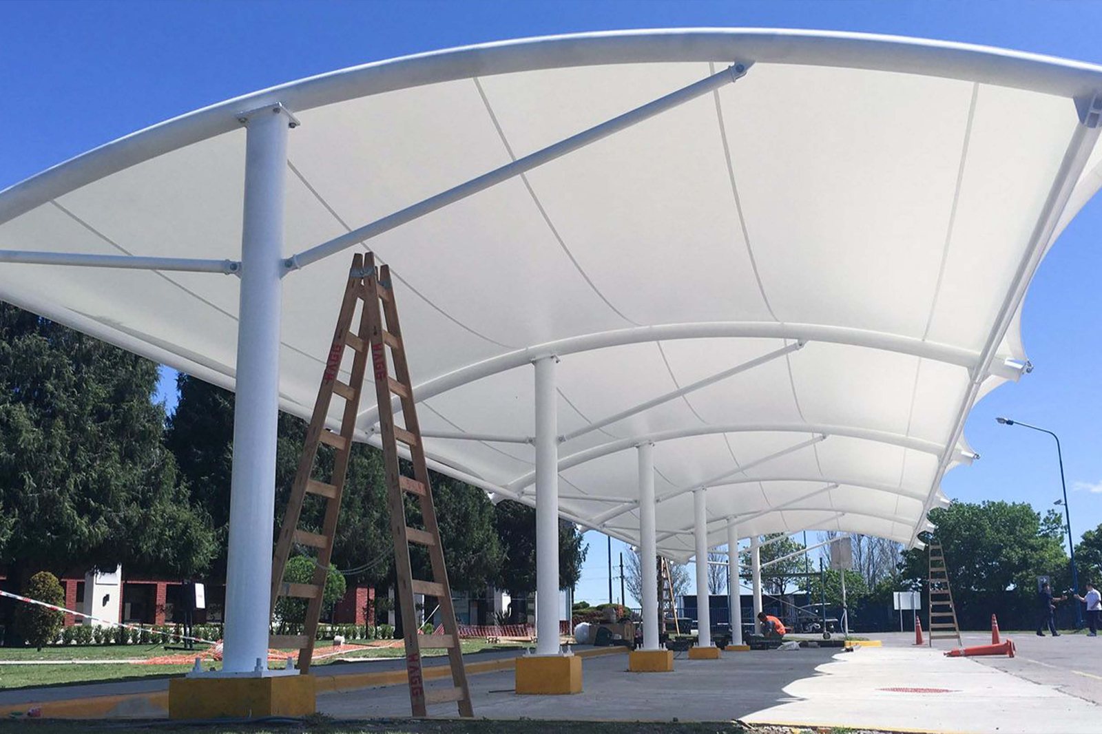 Sun Om Solution team installing a large tensile fabric canopy structure on site