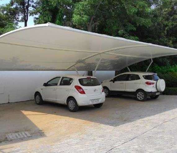 Tensile shade structure covering cars in a driveway