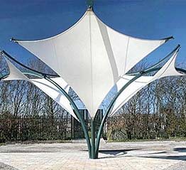 Decorative tensile pergola-style shade structure in an outdoor plaza