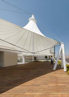 Conical tensile shade structure over a rooftop terrace deck